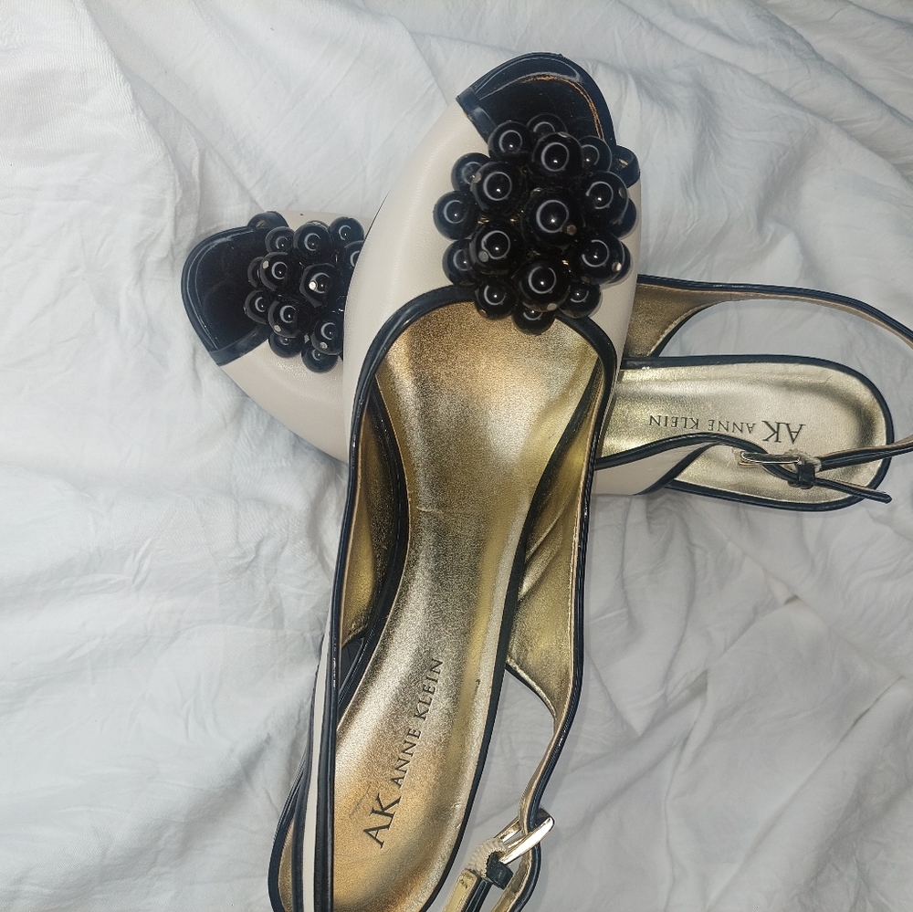 Elegant black pearl strap cream heels.